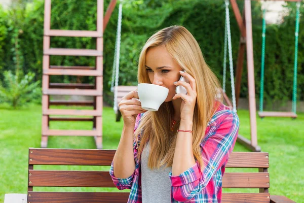 Mulher bebendo café e conversando por telefone — Fotografia de Stock