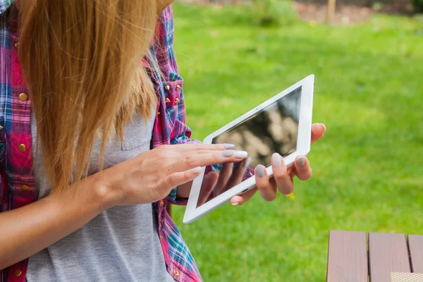 Žena sedí v parku a použití počítače tablet pc — Stock fotografie