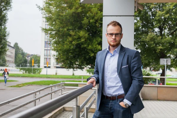 Businessman in front of office block — Stock Photo, Image