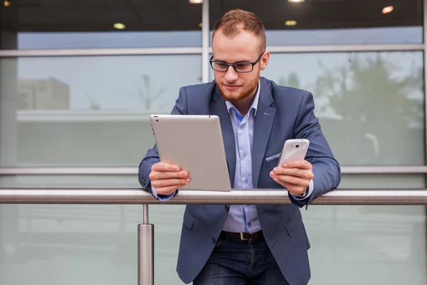 Zakenman met behulp van de mobiele telefoon en tablet pc — Stockfoto