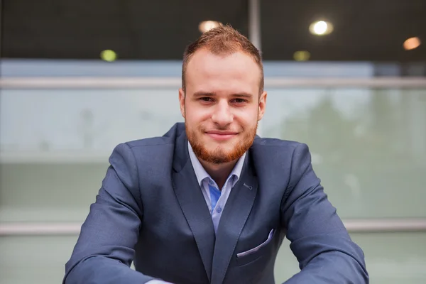 Businessman in front of office block — Stock Photo, Image