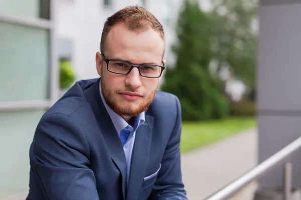 Businessman in front of office block — Stock Photo, Image