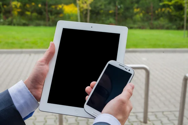 Zakenman handen met mobiele telefoon en tablet pc — Stockfoto