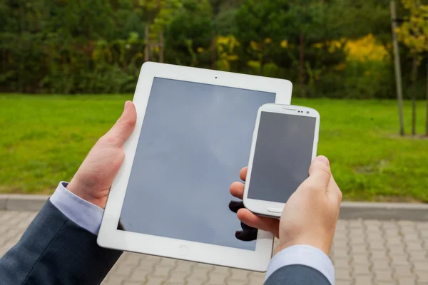 Zakenman handen met mobiele telefoon en tablet pc — Stockfoto