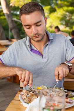 Genç adam yeme seafod.