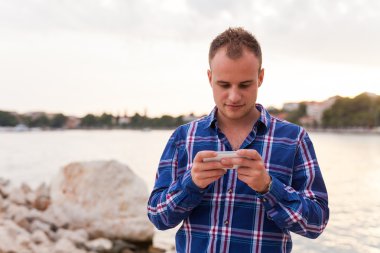 Adam deniz kıyısı ve telefon kullanma.