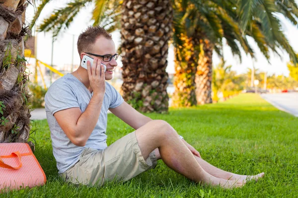 Tourist  under palm  with mobile phone — Stock Photo, Image