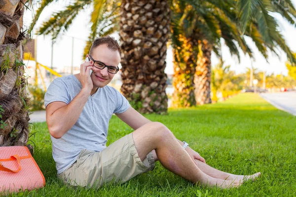 Turist under palm med mobiltelefon — Stockfoto