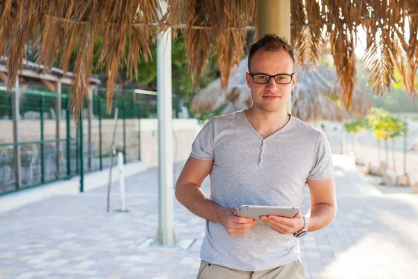 Tourist unter Palme mit Tablet-PC. — Stockfoto