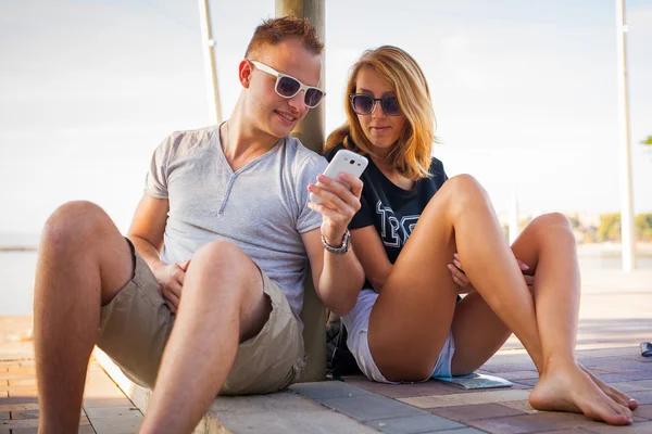 Couple  near sea with phone — Stock Photo, Image