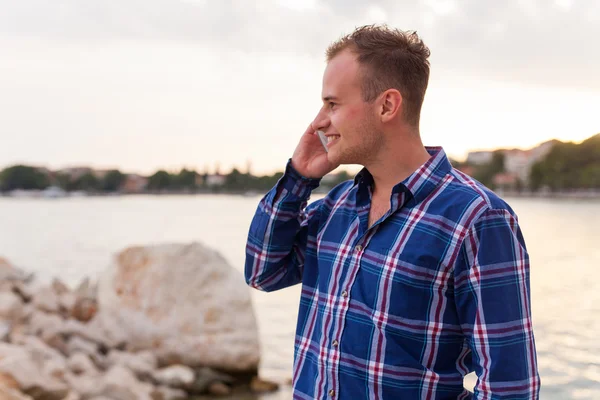 Man på havsstranden och med telefonen. — Stockfoto