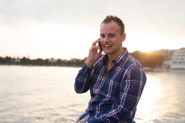 Man met behulp van telefoon aan kust — Stockfoto