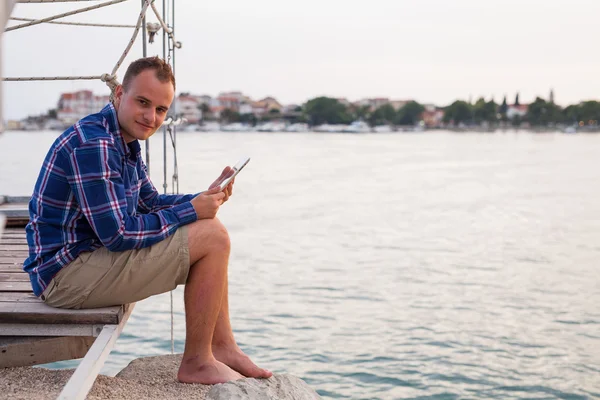 Mann in der Nähe des Meeres und mit Tablet. — Stockfoto