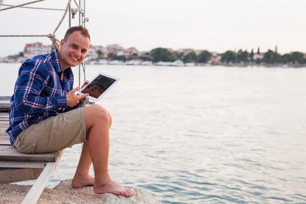 Adamın yanında deniz ve tablet kullanma. — Stok fotoğraf