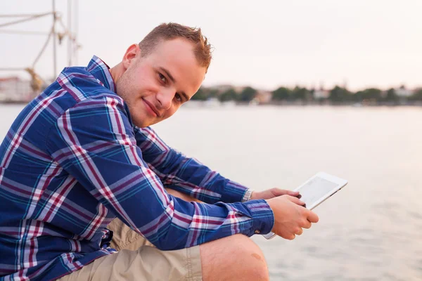 Homme près de la mer et utilisant une tablette . — Photo