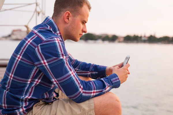 Man in de buurt van de zee en het gebruik van de telefoon — Stockfoto