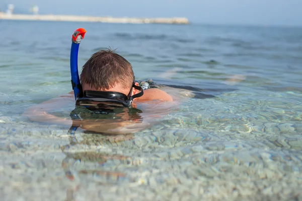 Мальчик плавает в море в маске — стоковое фото