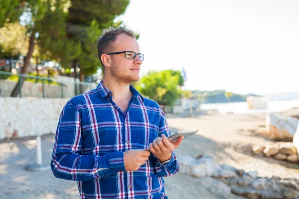 Young tourist in shirt with mobile tablet pc — Stockfoto