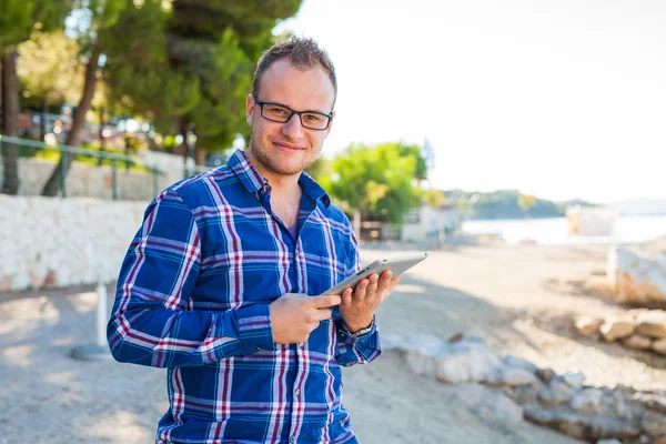 Turysta z mobilnych typu Tablet na plaży. — Zdjęcie stockowe