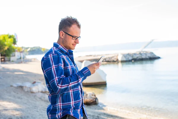 Tourist with mobile phone on  Croatian beach. — Stock Photo, Image