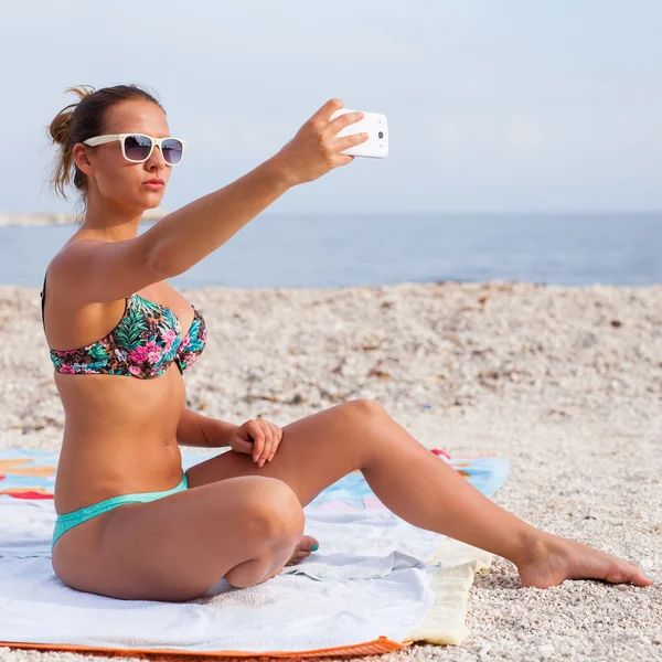 Mooi meisje op het strand met telefoon — Stockfoto