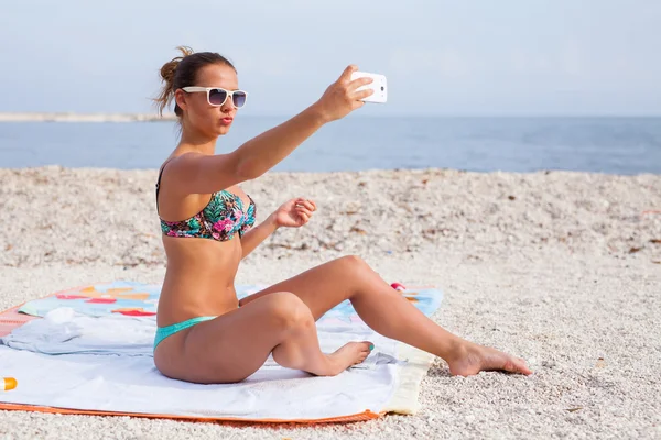 Красива дівчина на пляжі з телефоном — стокове фото