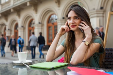 Kafe ve telefonla konuşurken kız