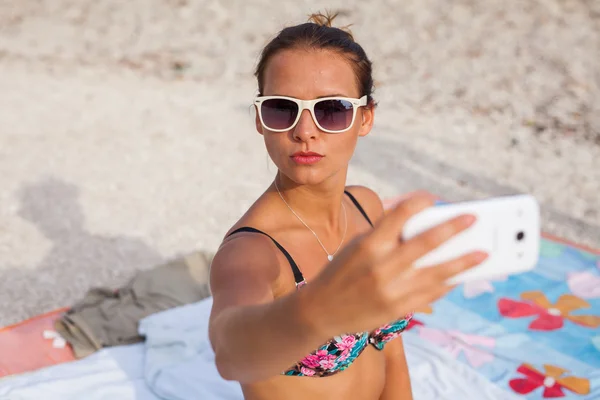 Mooi meisje op het strand met telefoon — Stockfoto