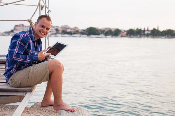 Muž blízko moře a použití tabletu. — Stock fotografie