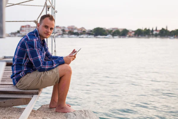 Muž blízko moře a použití tabletu. — Stock fotografie