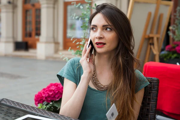 Девушка разговаривает по телефону в кафе — стоковое фото