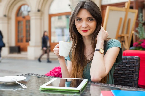 Girl sitting in cafe drinking coffee — Stock Photo, Image