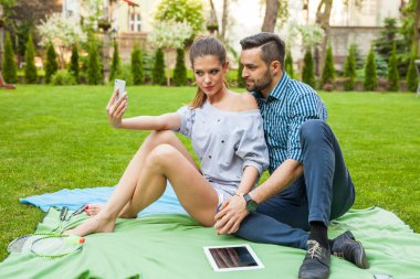 Çift blaket üzerinde oturan ve selfie alarak