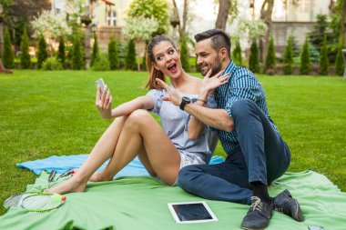 Çift blaket üzerinde oturan ve selfie alarak