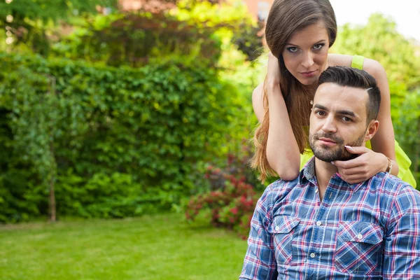 Couple sitting on  bench in the garden. — Stock Photo, Image