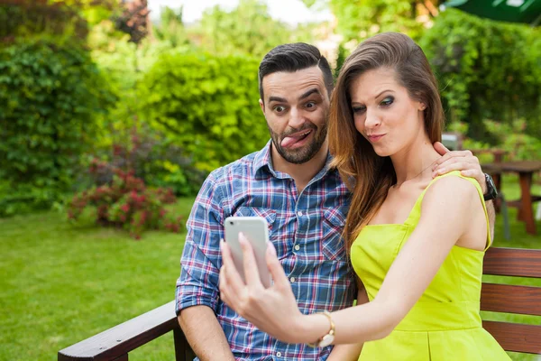 Paar im Garten und macht Selfie. — Stockfoto