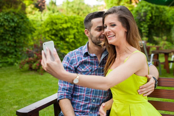 Paar im Garten und macht Selfie. — Stockfoto