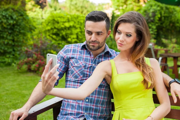 Casal no jardim e tomando selfie . — Fotografia de Stock