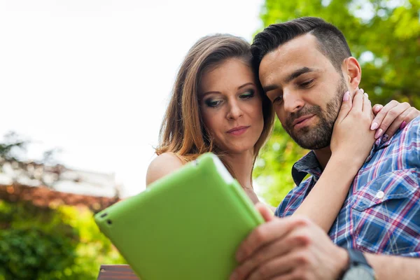 Paar benutzt Tablet und lächelt — Stockfoto