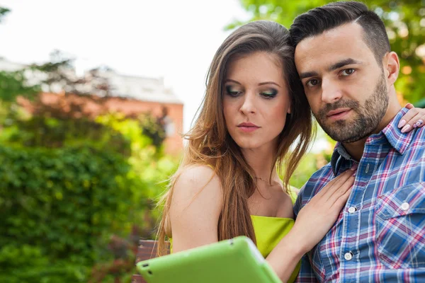 Coppia utilizzando tablet e sorridente — Foto Stock