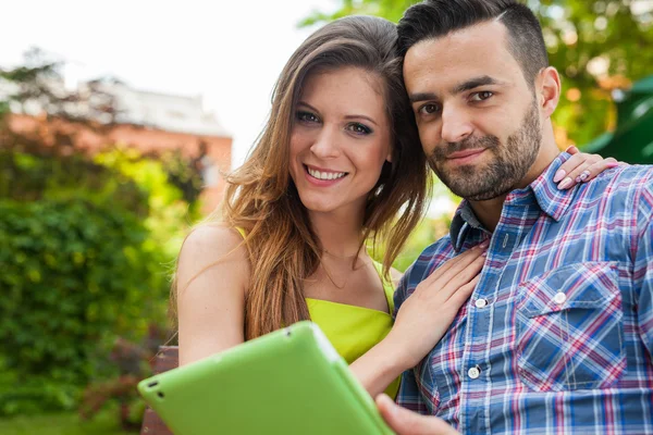 Pareja usando tableta y sonriendo — Foto de Stock