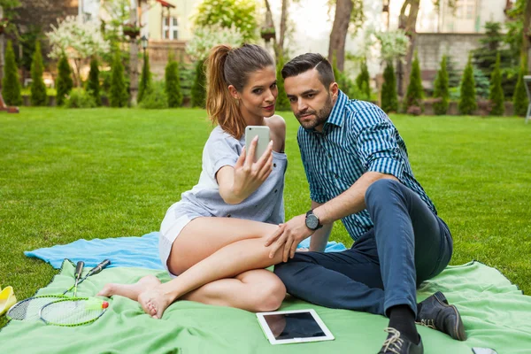 Paar, das auf dem Blaket sitzt und Selfie macht — Stockfoto