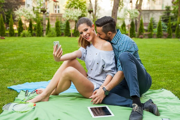 Paar sitzt auf der Blaket und macht Selfie — Stockfoto