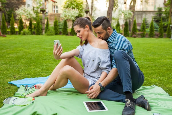 Paar sitzt auf der Blaket und macht Selfie — Stockfoto