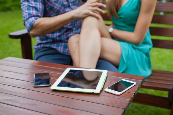 Smartphones auf dem Tisch neben sitzendem Paar. — Stockfoto