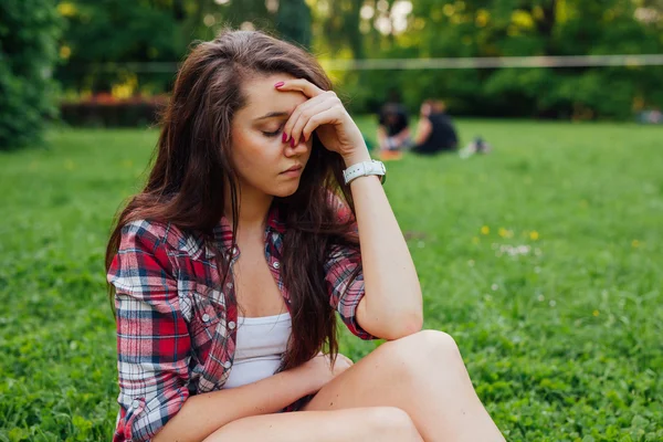 Chica tiene dolor de cabeza en el parque — Foto de Stock