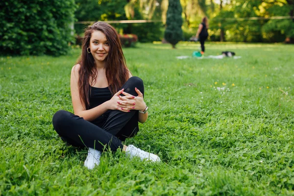 Çimenlerin üzerinde oturan kumral kız