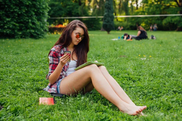 Bruna donna utilizzando tablet nel parco — Foto Stock