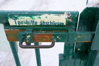 Almanya 'da bahçe yolu üzerinde bir kapı. Kapıda yazı var. Lütfen kilitleyin.                               
