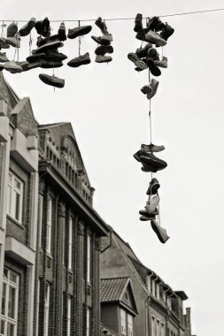 Siyah-beyaz görüntü, Shoefiti, Almanya 'da Luneburg şehir merkezinde asılı ayakkabılar.
